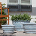Mera Planter in Murano Celeste on concrete in the backyard.