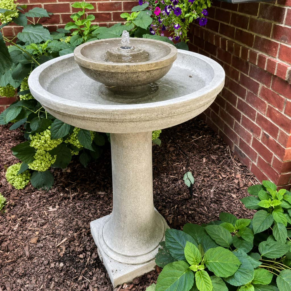 Meridian Fountain in action beside purple flowers.