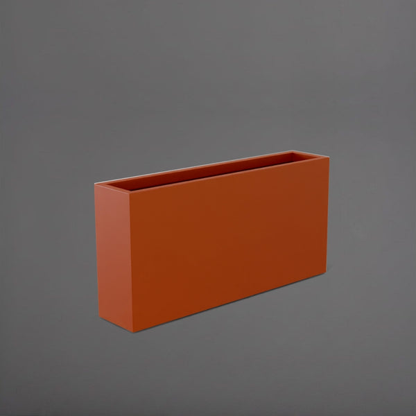 Milano Narrow Rectangle Planter in matte terracotta against gray background.