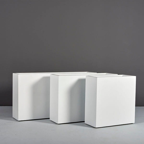 Milano Narrow Rectangle Planter on concrete against gray wall.