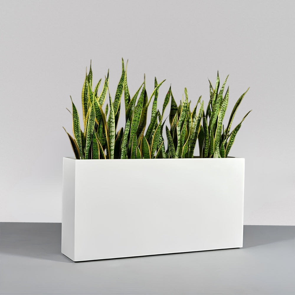 Milano Narrow Rectangle Planter on concrete filled with plants.