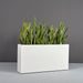 Milano Narrow Rectangle Planter on concrete filled with plants.