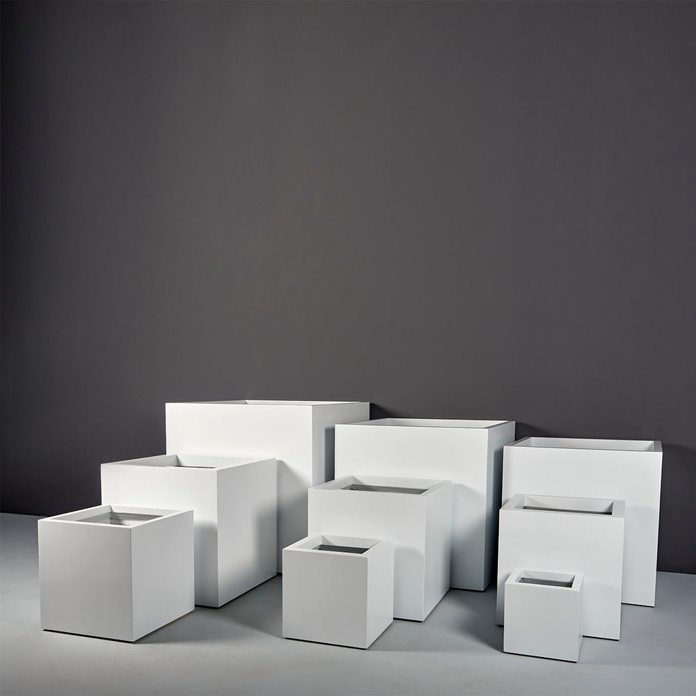 Montroy Cube Fiberglass Planter on concrete shown with different sizes.
