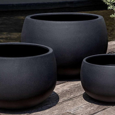 Norfolk Planter, Small in onyx black lite on concrete in the backyard.