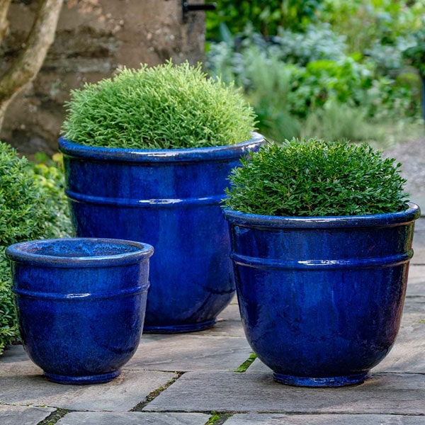 Origo Planter - Riviera Blue - S/3 on concrete filled with plants