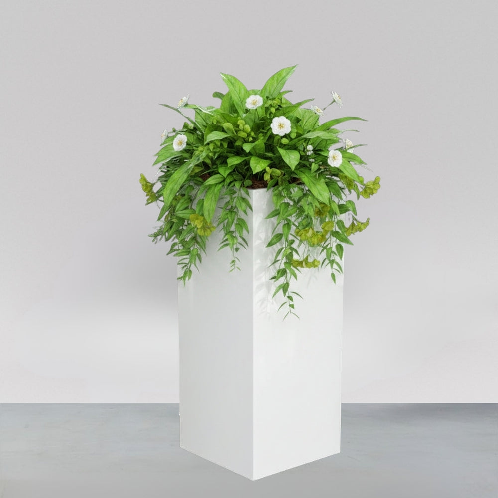 Perth Tall Corner Fiberglass Planter filled with plants against gray backdrop.