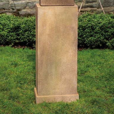 Rectangular Tall Pedestal on grass against green plants on the wall