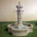 Roubaix Pond Fountain for Rustic Spouts on grass against cream wall.
