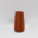 Saigon Tapered Round Fiberglass Planter in matte terra cotta against gray background.