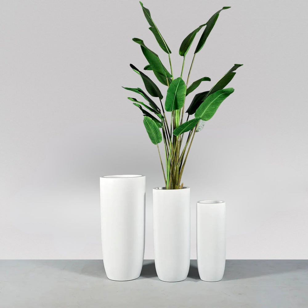 Saint Tropez Tall Bullet Round Fiberglass Planter shown with different sizes filled with plants.