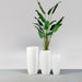 Saint Tropez Tall Bullet Round Fiberglass Planter shown with different sizes filled with plants.