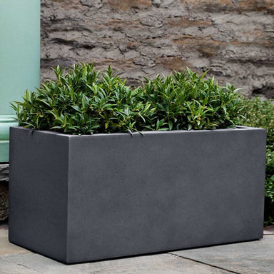 Sandal Planter 361818 S/1 in charcoal premium lite on concrete filled with plants.