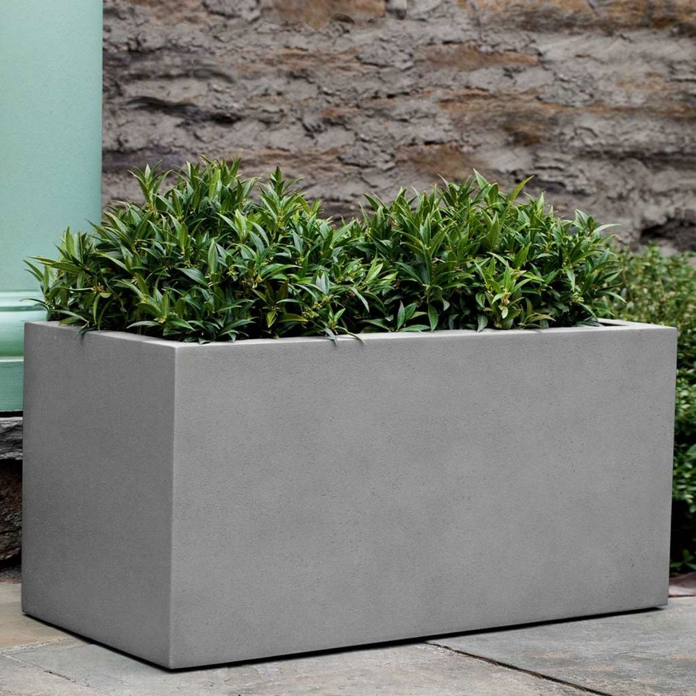 Sandal Planter 361818 S/1 in stone grey lite on concrete filled with plants.