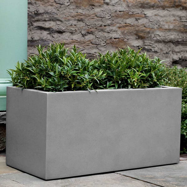 Sandal Planter 361818 S/1 in stone grey lite on concrete filled with plants.