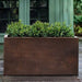 Sandal Planter 482424 S/1 in rust lite on concrete filled with plants.