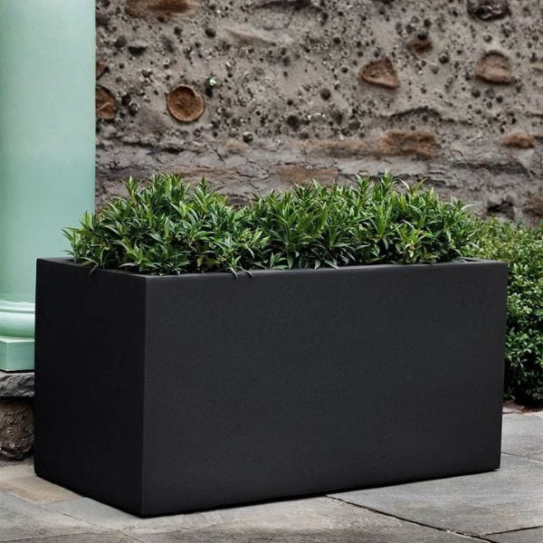 Sandal Planter 592424 S/1 in onyx black lite on concrete filled with plants.