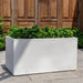 Sandal Planter S/1 in quartz premium on concrete filled with plants.