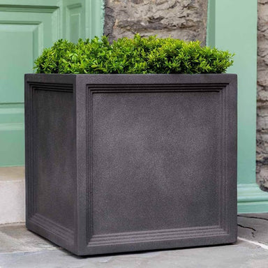 Campania International Sandhurst Square Planter, Large on concrete filled with plants.