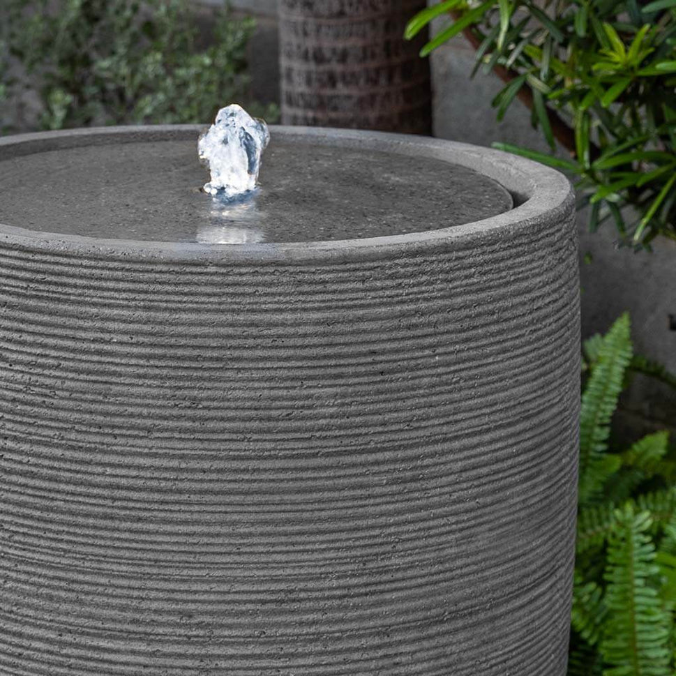 Sedona Bubbling Water feature in stone ledge in action near plants upclose.