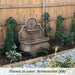 Segovia Fountain n action against wooden fence.
