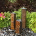 Semi Polished Basalt Fountain Kit on black pebbles in the backyard