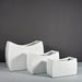 Seoul Modern Curved Rectangle Fiberglass Planter on concrete shown with three different sizes.