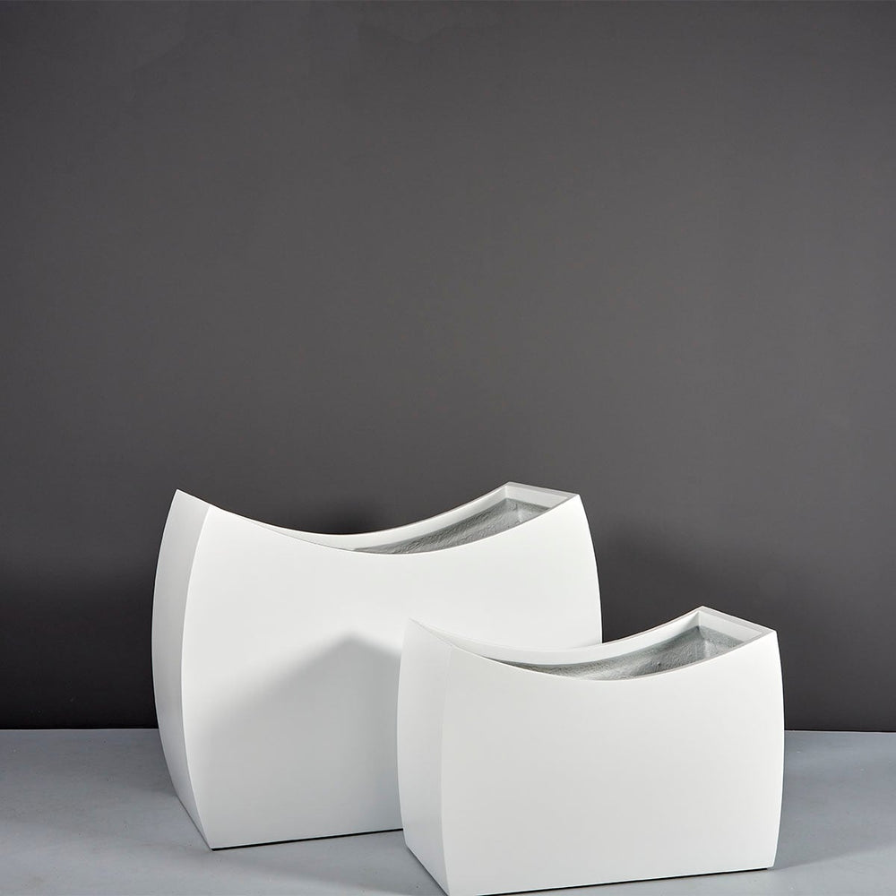 Seoul Modern Curved Rectangle Fiberglass Planter on concrete shown with two different sizes.