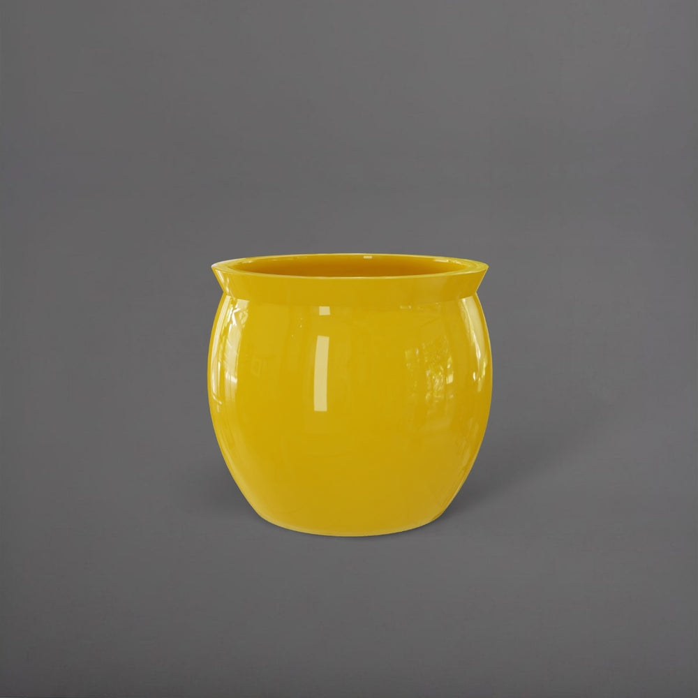 Shanghai Fishbowl Fiberglass Planter in gloss saffron against gray background.