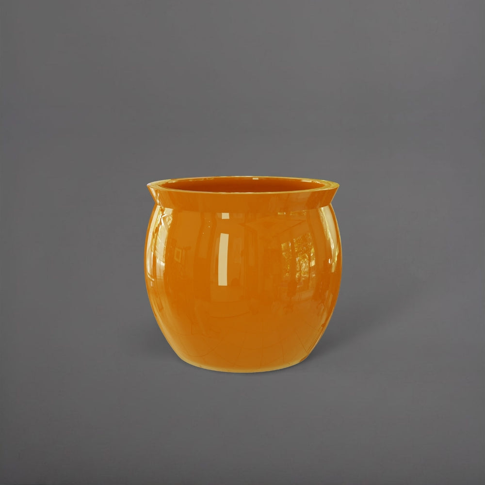 Shanghai Fishbowl Fiberglass Planter in gloss tangerine against gray background.