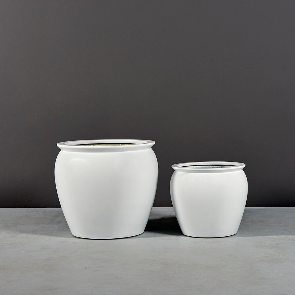 Shanghai Fishbowl Fiberglass Planter on concrete shown with different sizes.