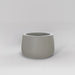 Short Hayden Tapered Round Fiberglass Planter in matte cement grey against gray background.