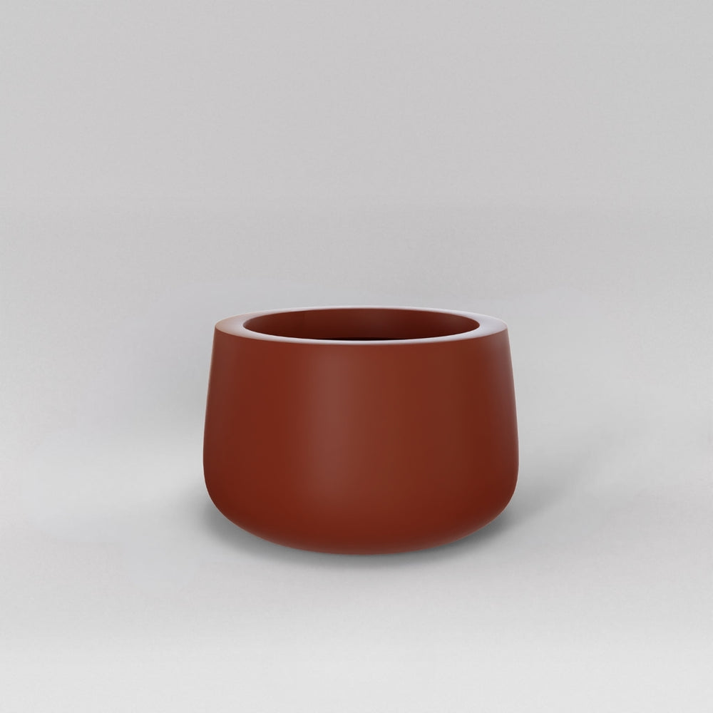 Short Hayden Tapered Round Fiberglass Planter in matte terra cotta against gray background.