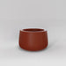 Short Hayden Tapered Round Fiberglass Planter in matte terra cotta against gray background.