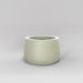 Short Hayden Tapered Round Fiberglass Planter in satin beige against gray background.