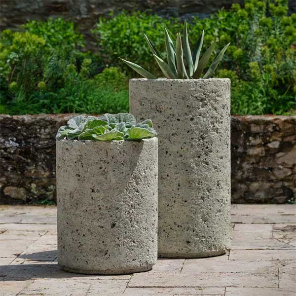 Siros Planter on concrete filled with plants in the backyard