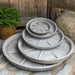 Small Campania Plant Saucers on concrete in the backyard.