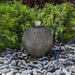 Small Ribbed Black Sphere Fountain Kit on Black Peebles against green leaves