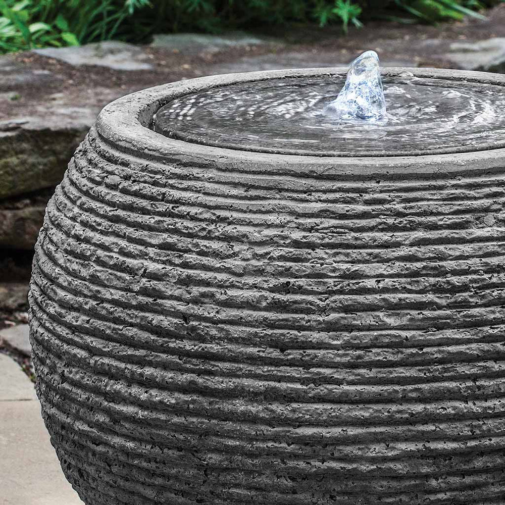 large sonora fountain in black stone ledge in action upclose.