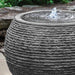 large sonora fountain in black stone ledge in action upclose.