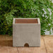 Splash Guard Square Wide on table against green leaves.
