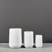 Tall Hayden Tapered Round Fiberglass Planter on concrete shown with different planter sizes.