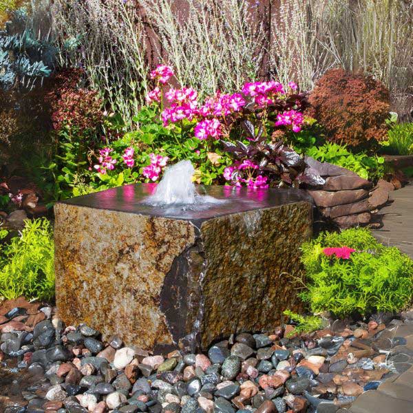 Tamaishi Fountain Kit on gravel beside pink flowers