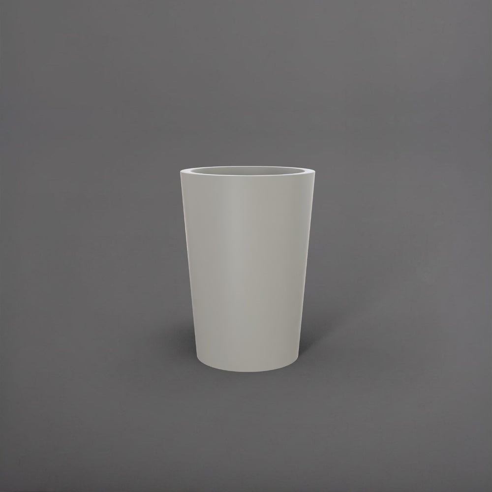 Tagel Tapered Round Fiberglass Planter in matte cement grey against gray background.