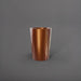 Tagel Tapered Round Fiberglass Planter in metallic bronze against gray background.