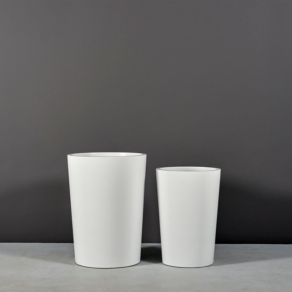 Tagel Tapered Round Fiberglass Planter on concrete shown in different sizes.