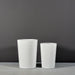 Tagel Tapered Round Fiberglass Planter on concrete shown in different sizes.