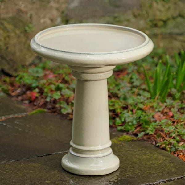 Terrace Birdbath in antique white on concrete in the backyard.