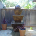Three Tier with Ball on concrete beside planters