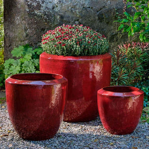 Timolos Round Planter - Tropic Red - S/3 on gravel filled with red flowers