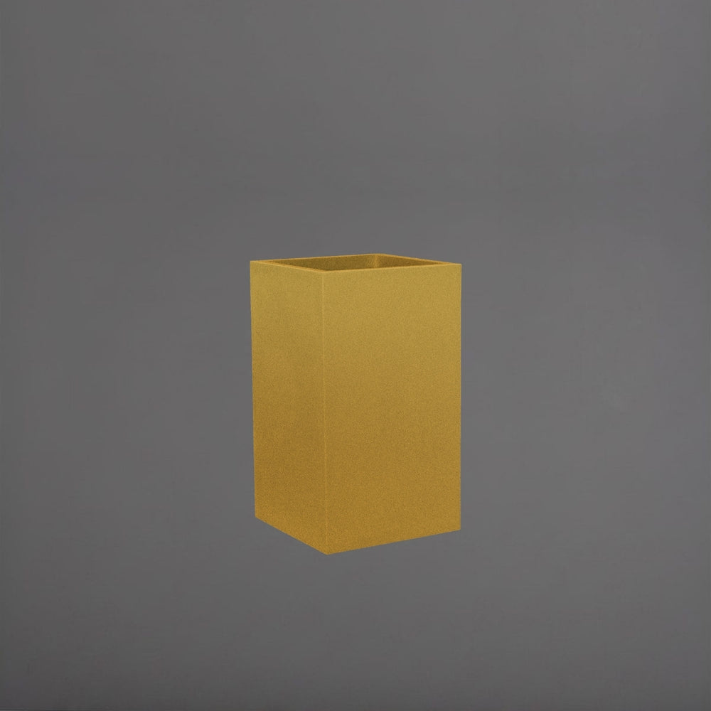 Tolga Corner Fiberglass Planter in gloss metallic gold against gray background.